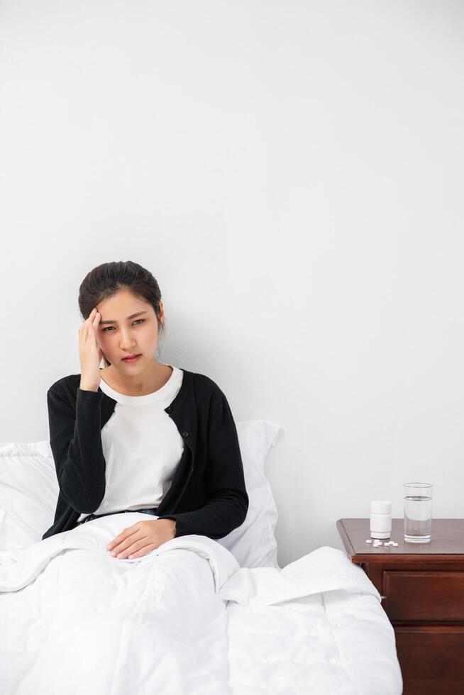 The sick woman had a headache and the hands touched her head on the bed. photo