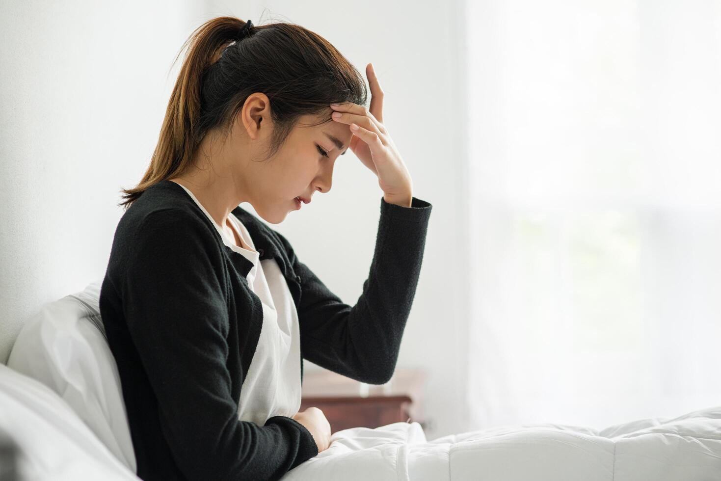 The sick woman had a headache and the hands touched her head on the bed. photo