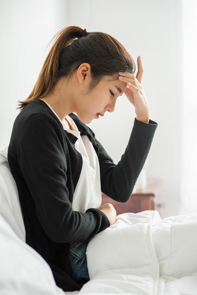 The sick woman had a headache and the hands touched her head on the bed. photo