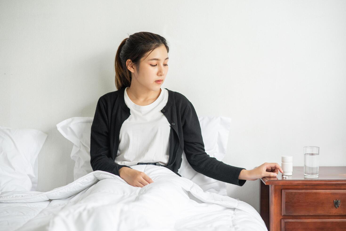 A woman who is unwell on the couch and is about to take antibiotics. photo