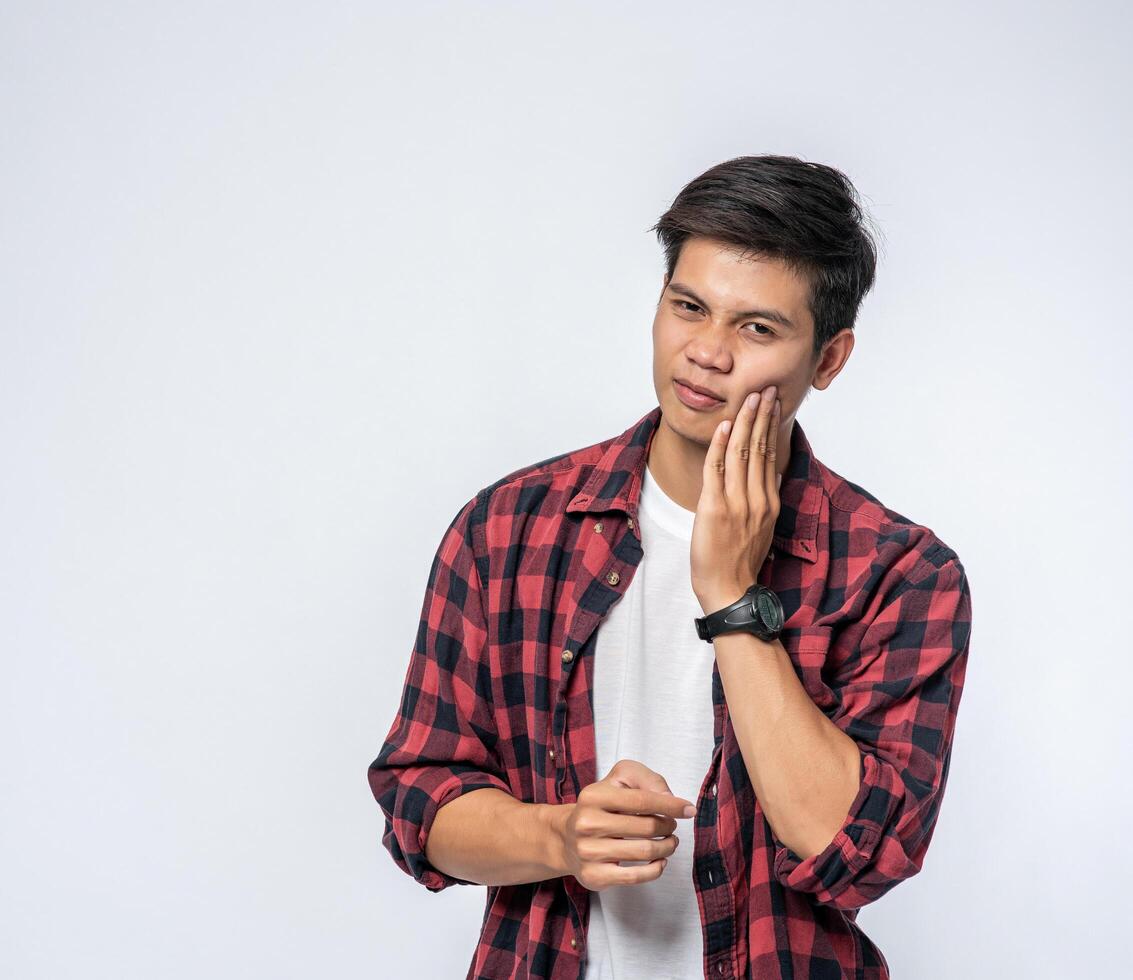 A man sick with a toothache and a hand holding on the cheek photo