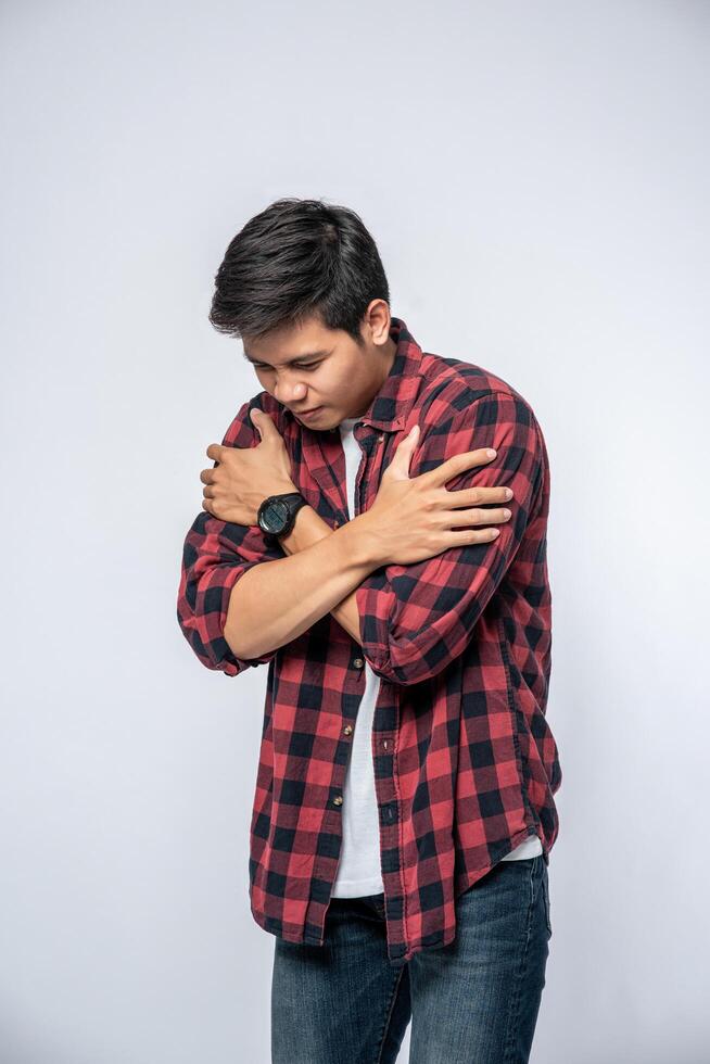 A man in striped shirts stood sick and folded his arms around. photo