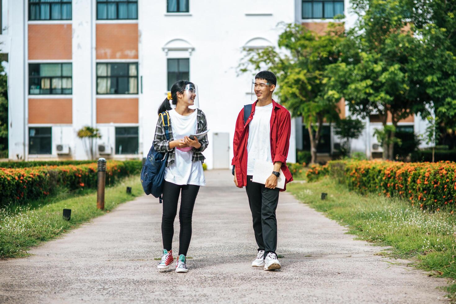 Male and female students wear a face Chill and stand in front of the university. photo