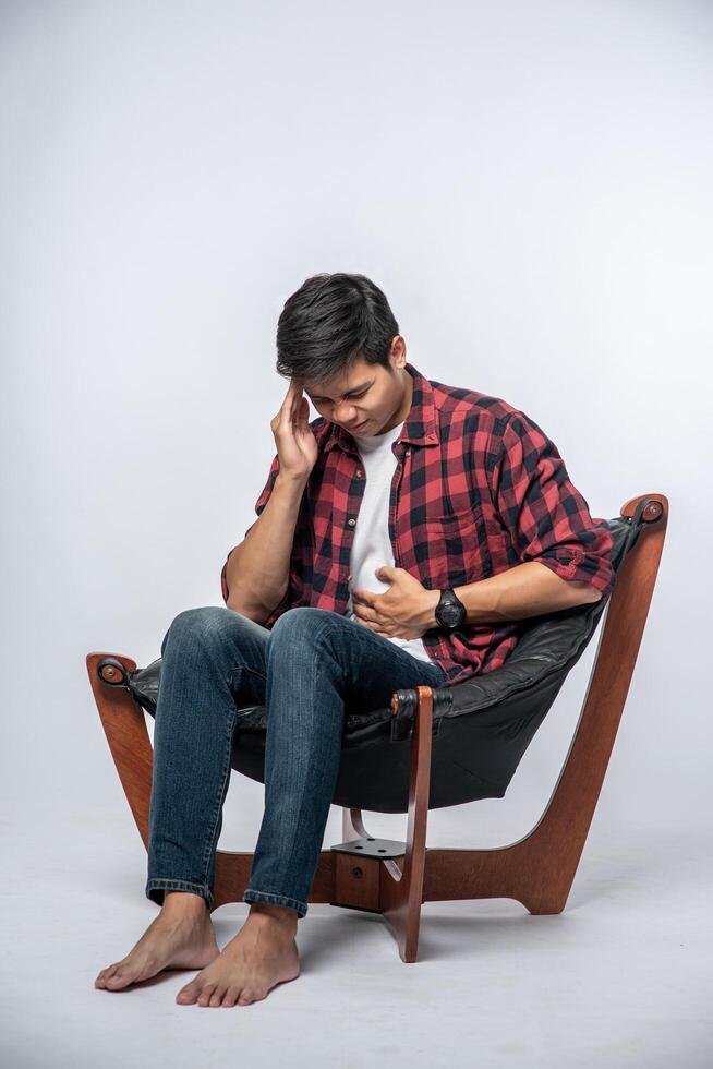 The man was sick, sat on a chair, and touched her head with her hand. photo