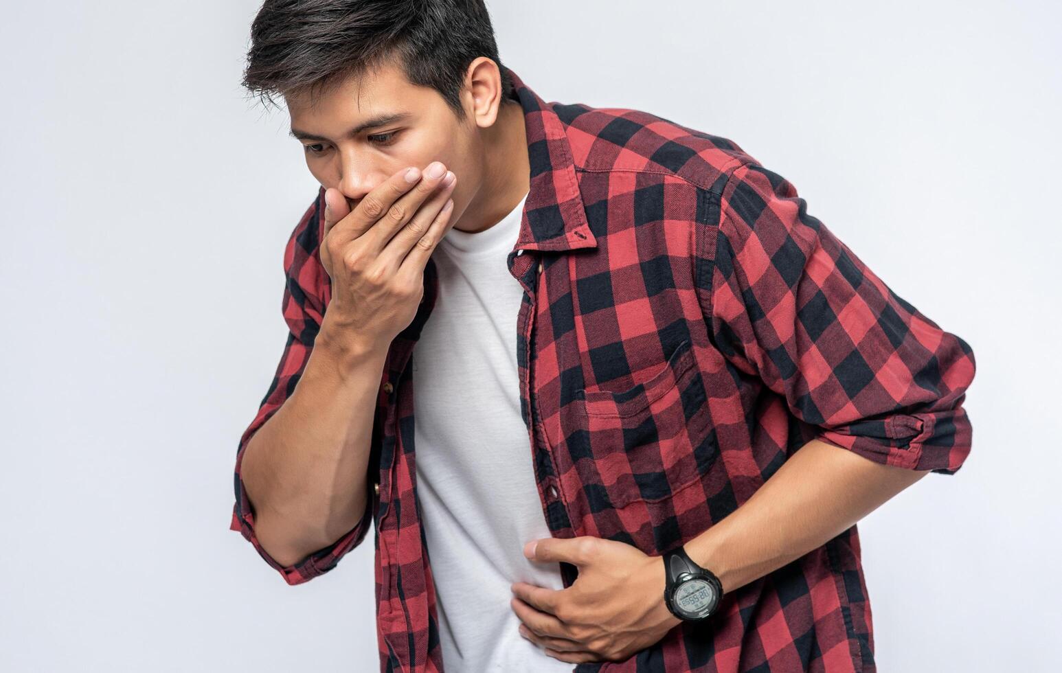 A man standing with a stomachache Put your hands on your stomach and cover your mouth. photo
