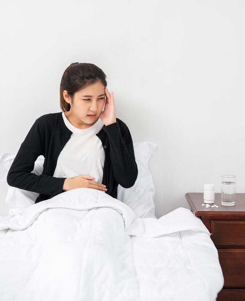 la enferma tenía dolor de cabeza y las manos le tocaban la cabeza en la cama. foto