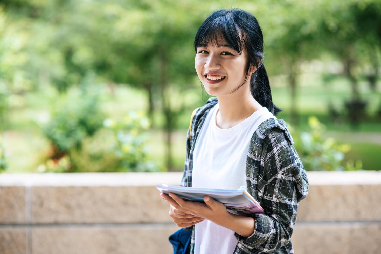 Female students stand on the stairs and hold books. photo