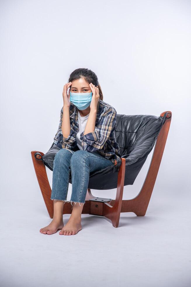 The woman was sick, sat on a chair, and touched her head with her hand. photo