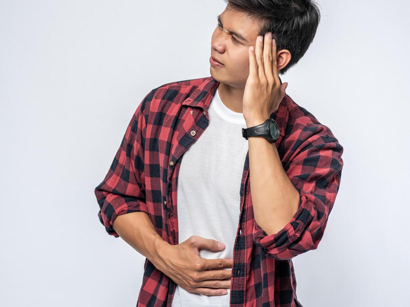 A man who is sick and touches his head with his hand. photo