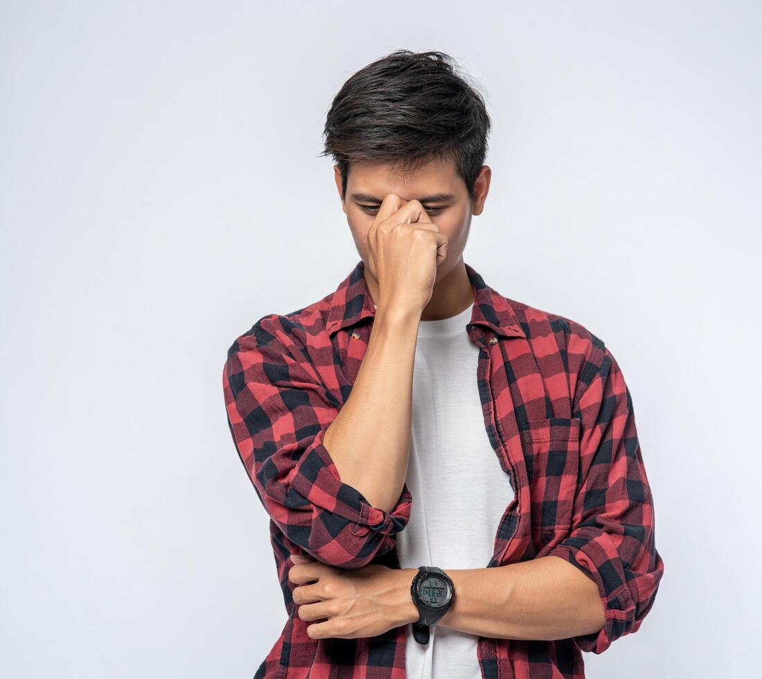 A man with a migraine headache holding her hand in her nose photo