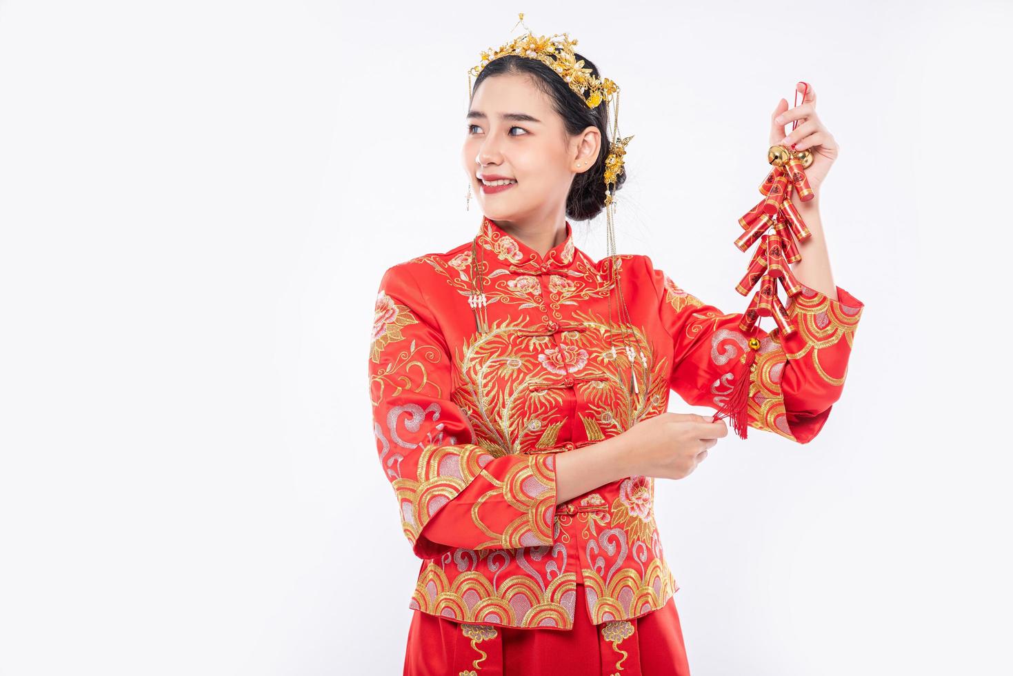 mujer usa traje cheongsam sonríe para obtener petardos del jefe en año nuevo chino foto