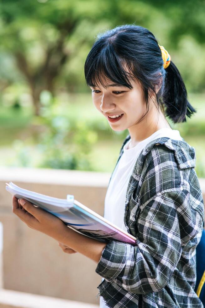 Female students stand on the stairs and hold books. photo