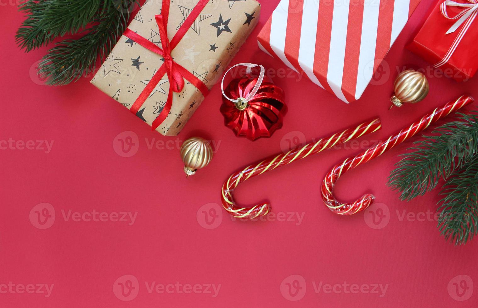 composición navideña. cajas como regalo en la rama de abeto en backgraund rojo. vista superior, espacio de copia foto