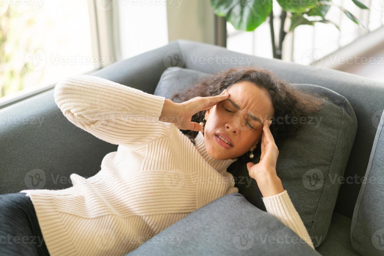 mujer latina, acostado, en, sofá, con, dolor de cabeza, sentimiento foto