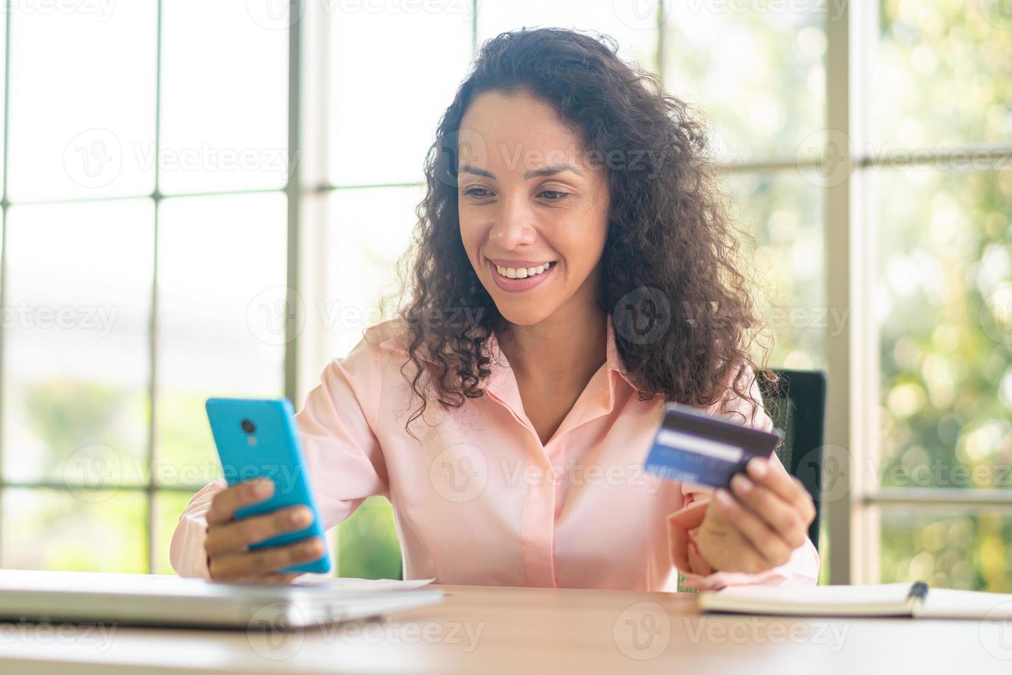 Hermosa mujer latina con smartphone con tarjeta de crédito foto