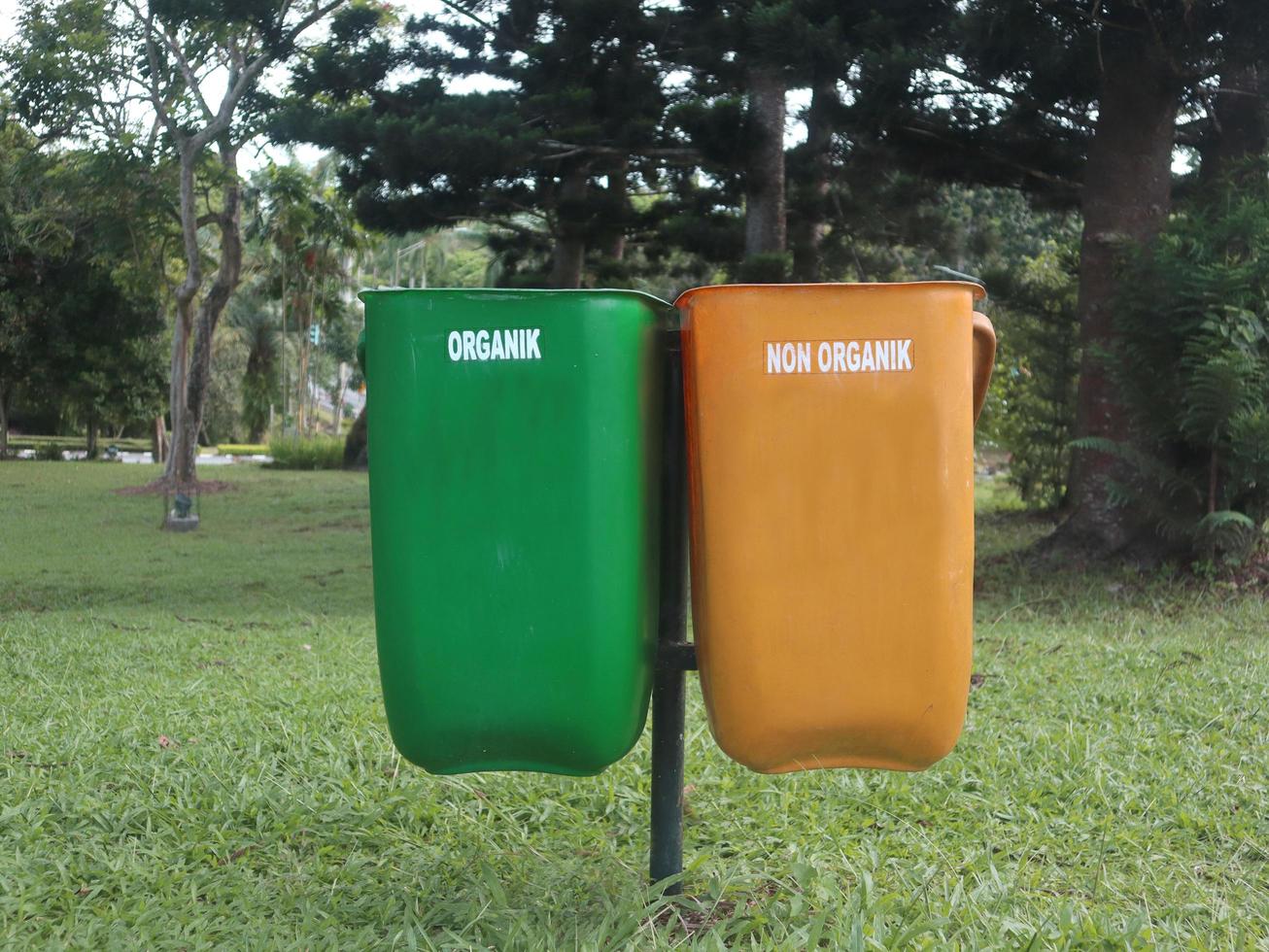 yellow bins for non-organic waste that cannot be recycled, and green for recyclable organic waste. placed in a park photo