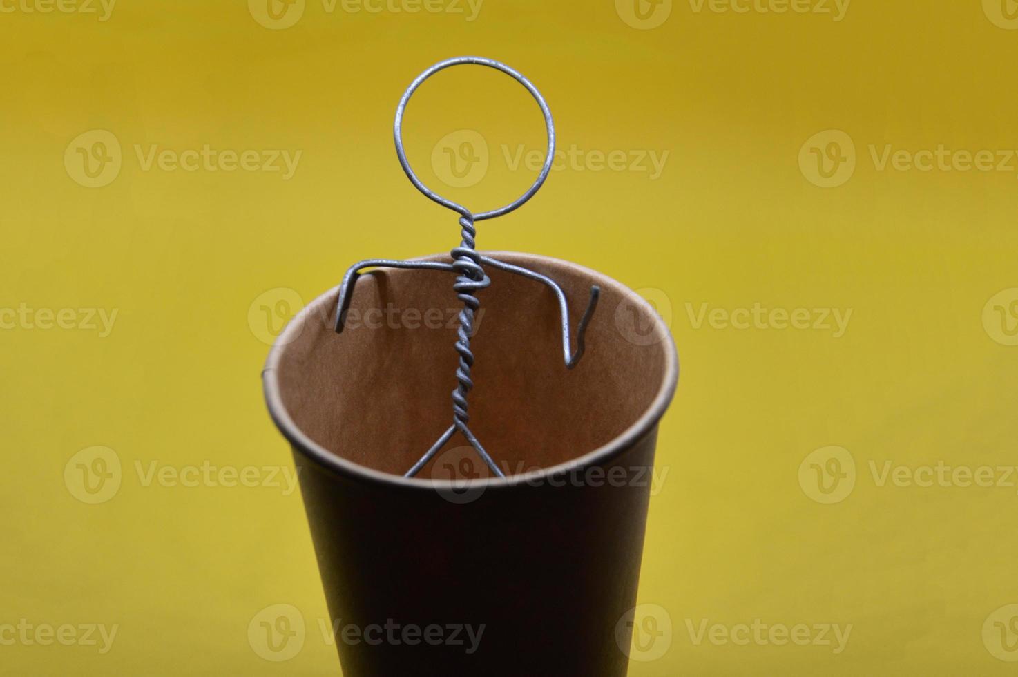 Human figure made of metal wire with an object photo