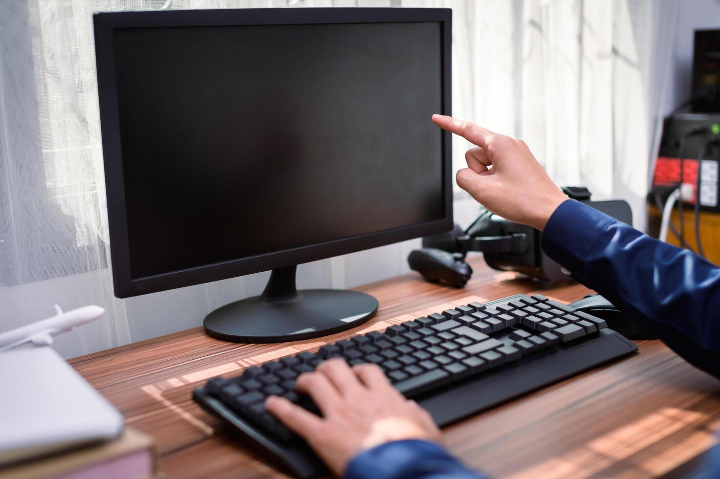 A person is pointing at a computer screen photo