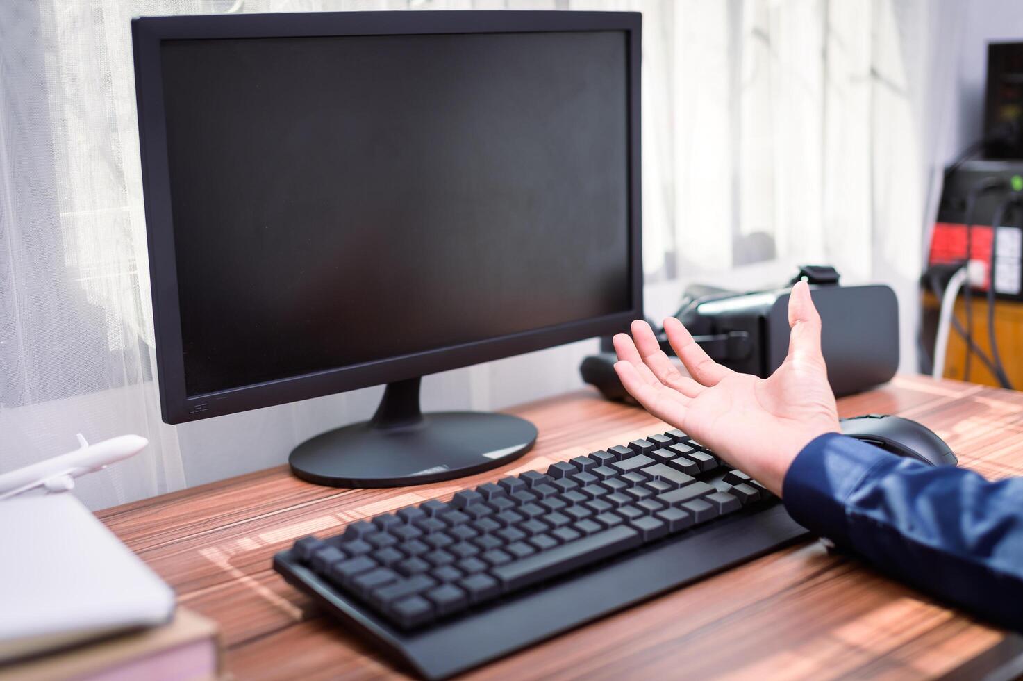 A person is sitting at a desk with a computer and a hand out photo