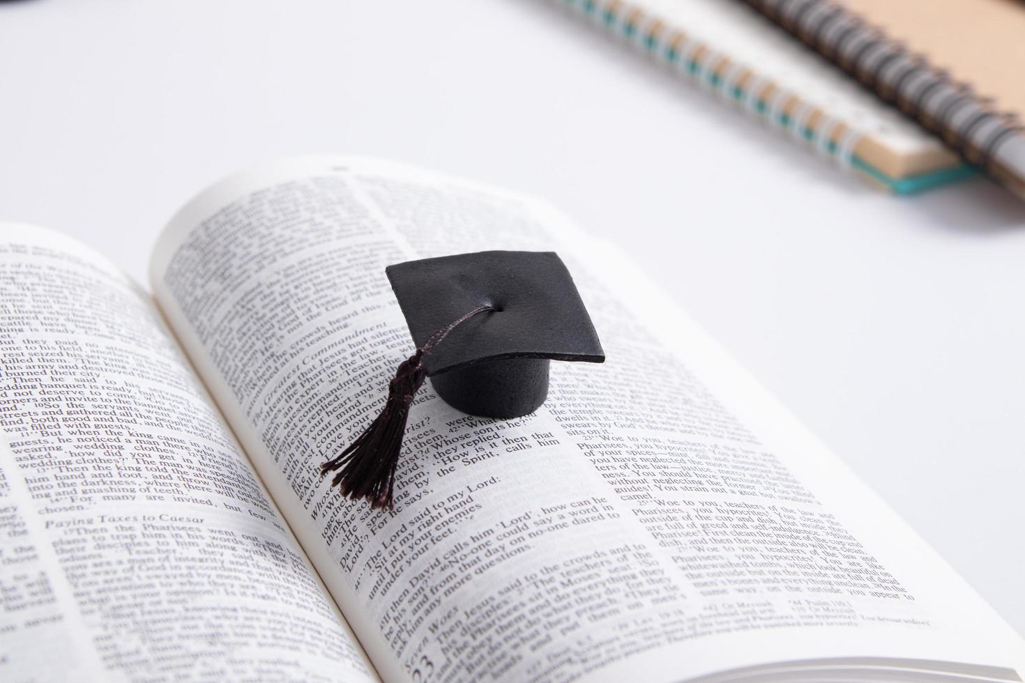 Graduate cap on the pages of the holy bible. Spiritual education concept photo