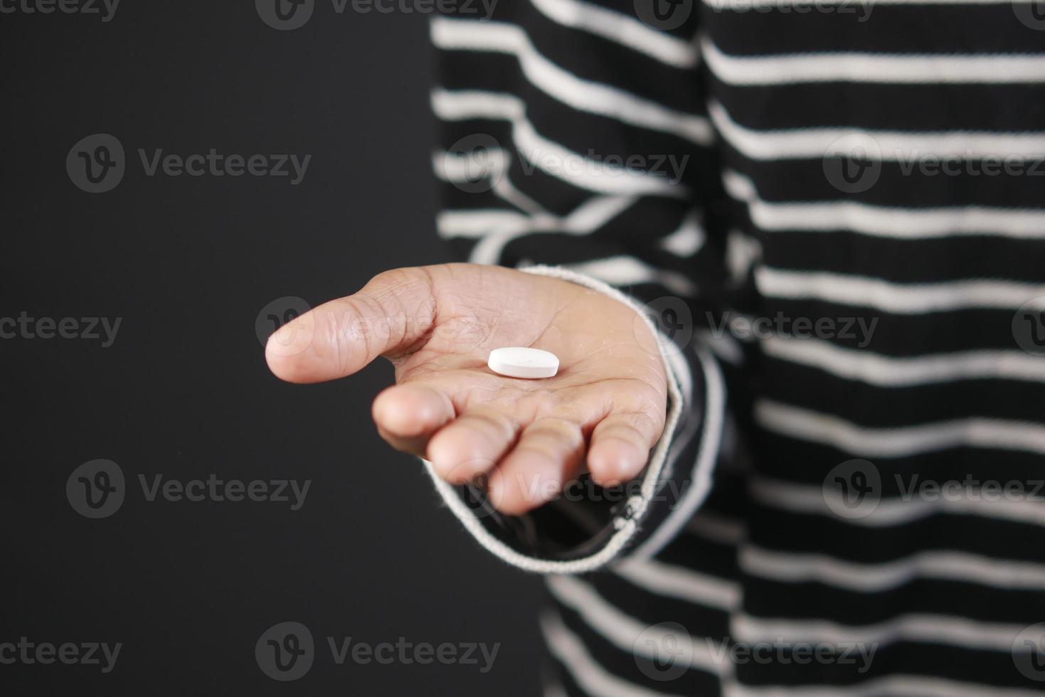 Cerca de píldoras médicas en la palma de la mano del niño foto