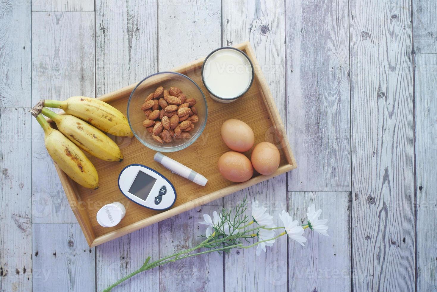 herramientas de medición para diabéticos, plátano, huevos, leche en la mesa foto