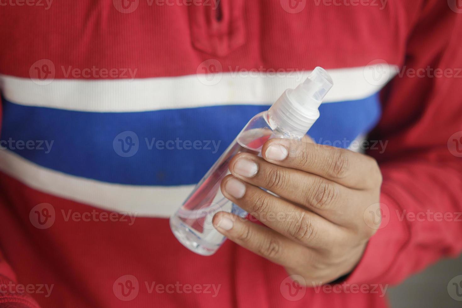 Cerca de la mano del hombre joven con spray desinfectante para manos. foto