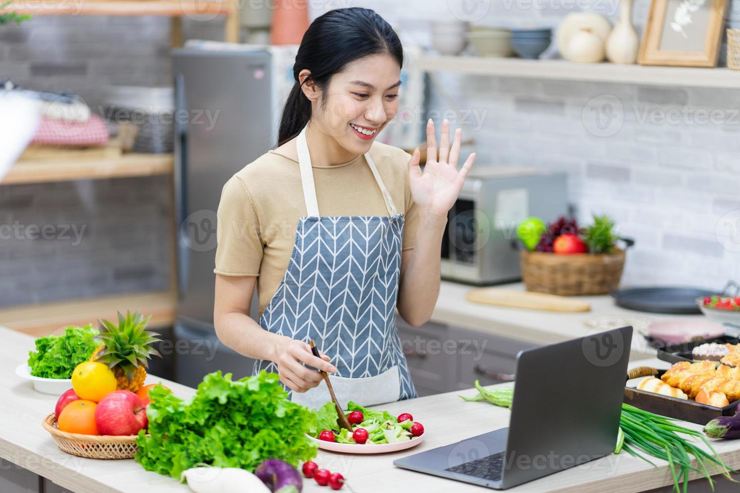 image of asian woman preparing salad in the kitchen photo