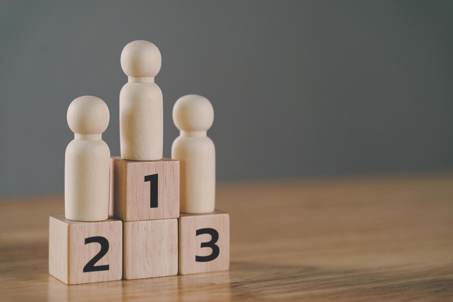 wooden figures peg doll standing on the podium 1st, 2nd, 3rd positions of wooden cube blocks with copy space. ranking and strategy concept. photo