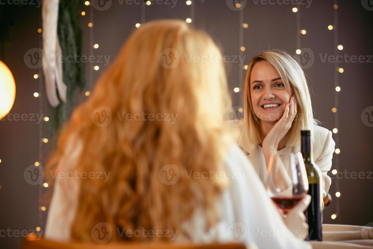 pareja de lesbianas cenando en un restaurante. niña dando un regalo a su amada foto