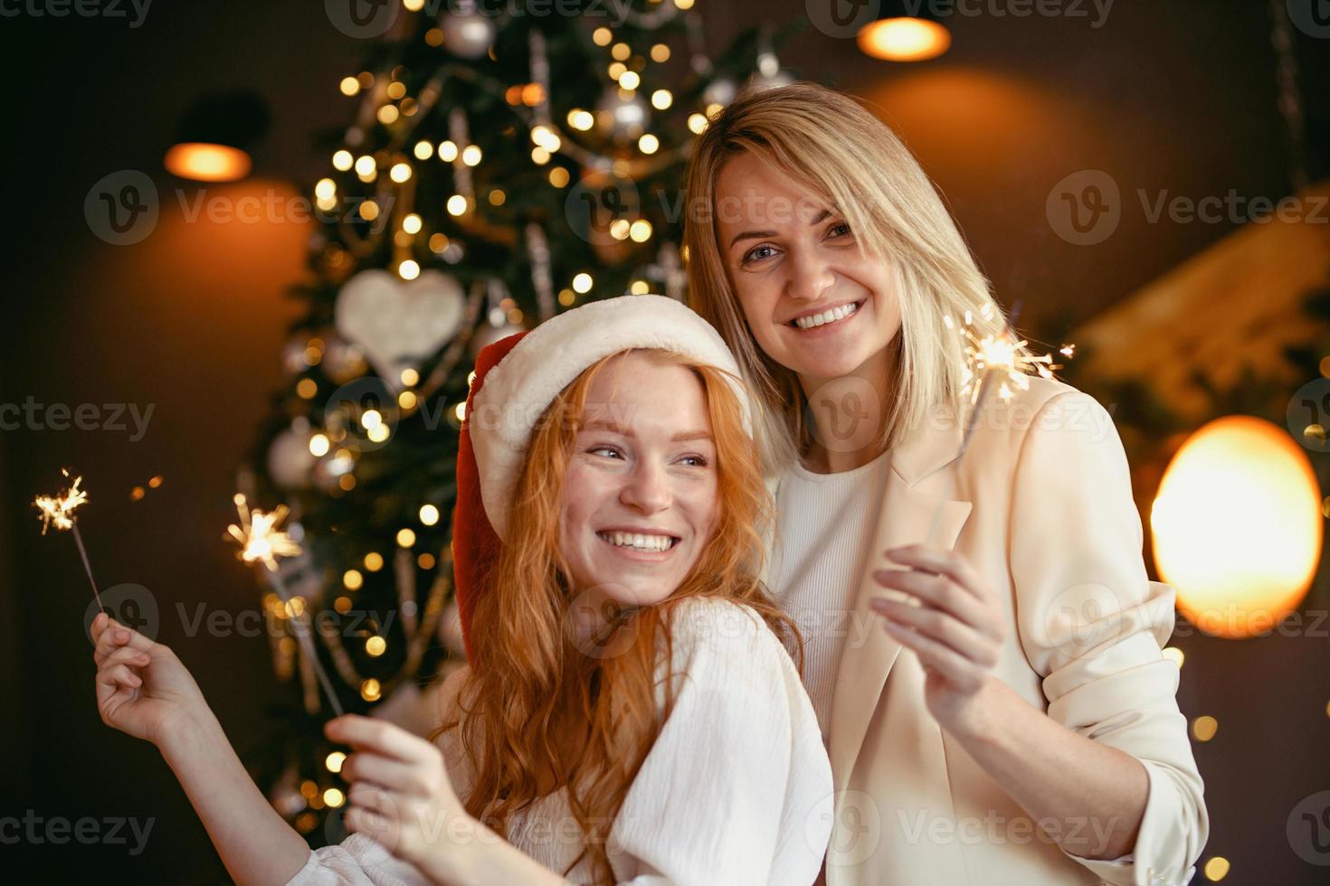 lesbian couple having dinner celebrating a holiday. Girls burn sparklers and smile at the camera photo