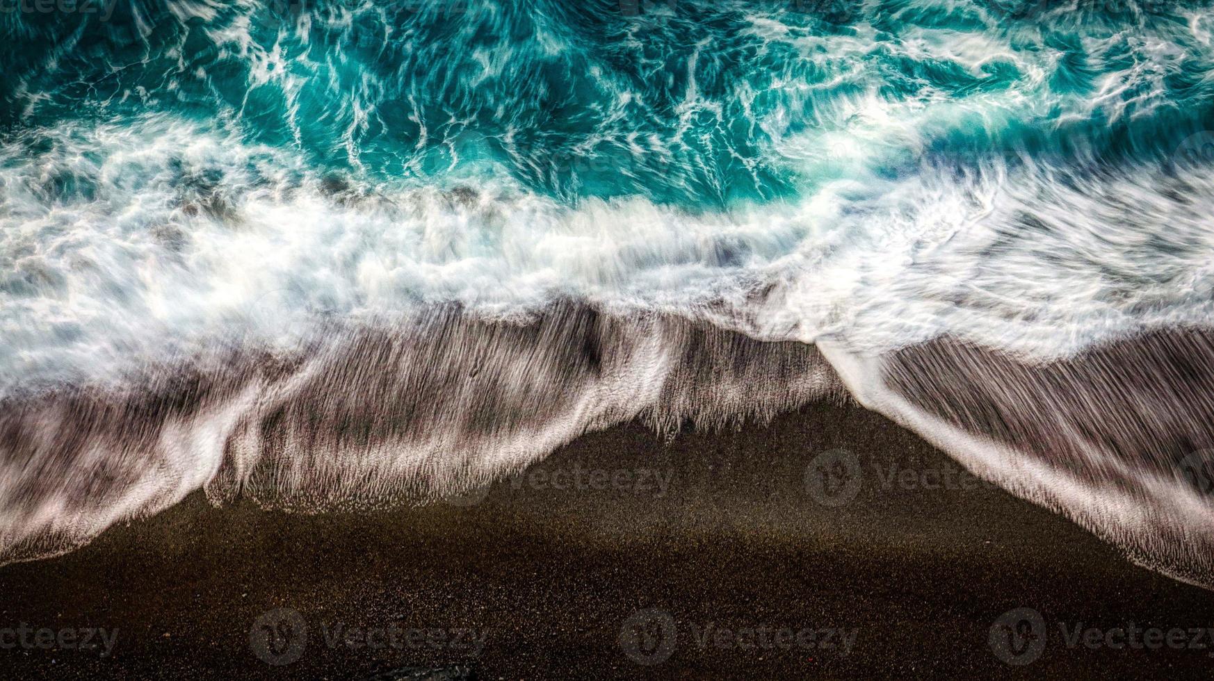 Las olas del mar rompen en la costa arenosa disparada desde arriba por un dron en las playas italianas foto