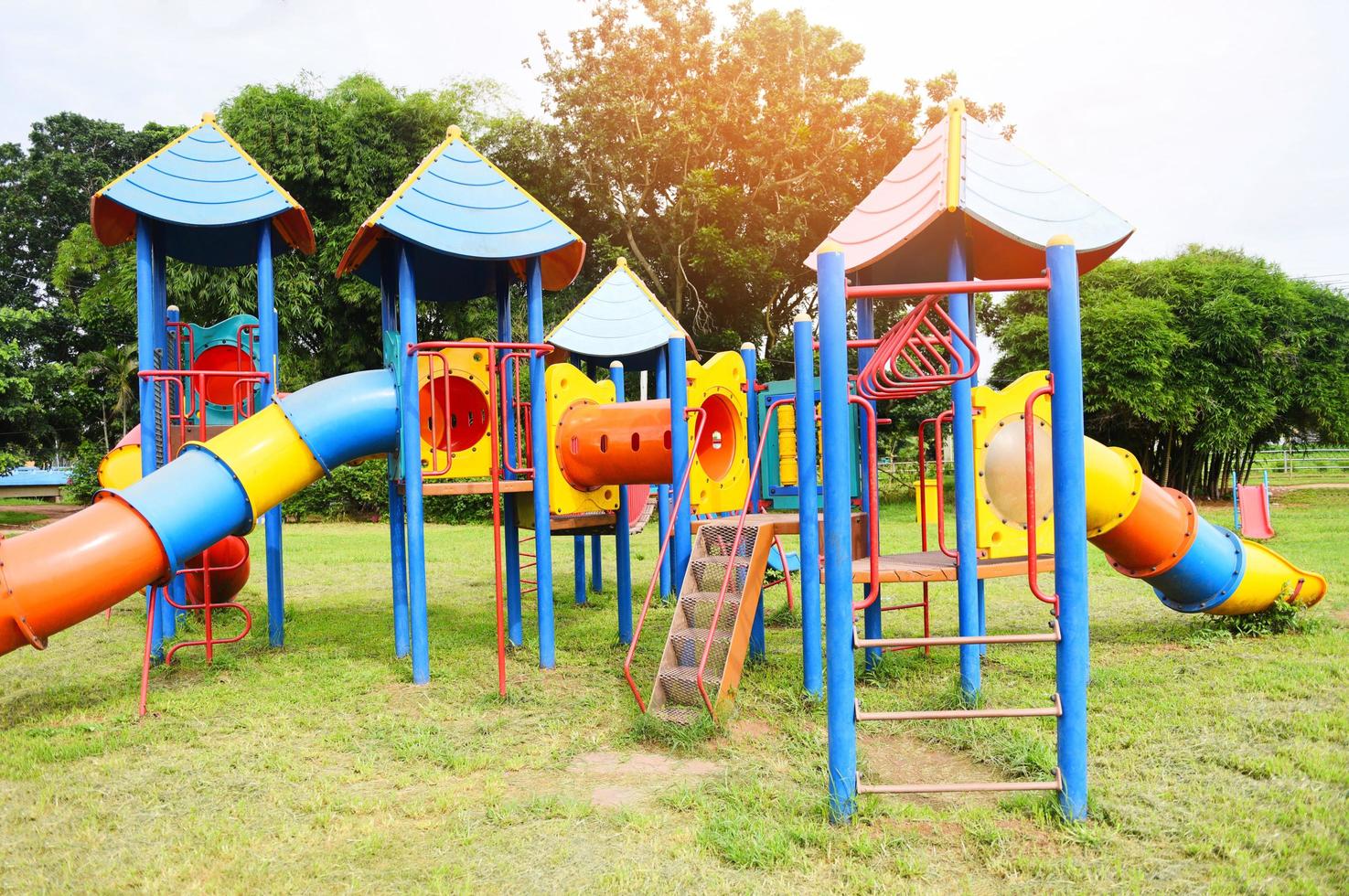 Zona de juegos para niños en actividades al aire libre en el jardín con  fondo de árboles verdes - Zona de juegos colorida en el patio del parque  4951298 Foto de stock