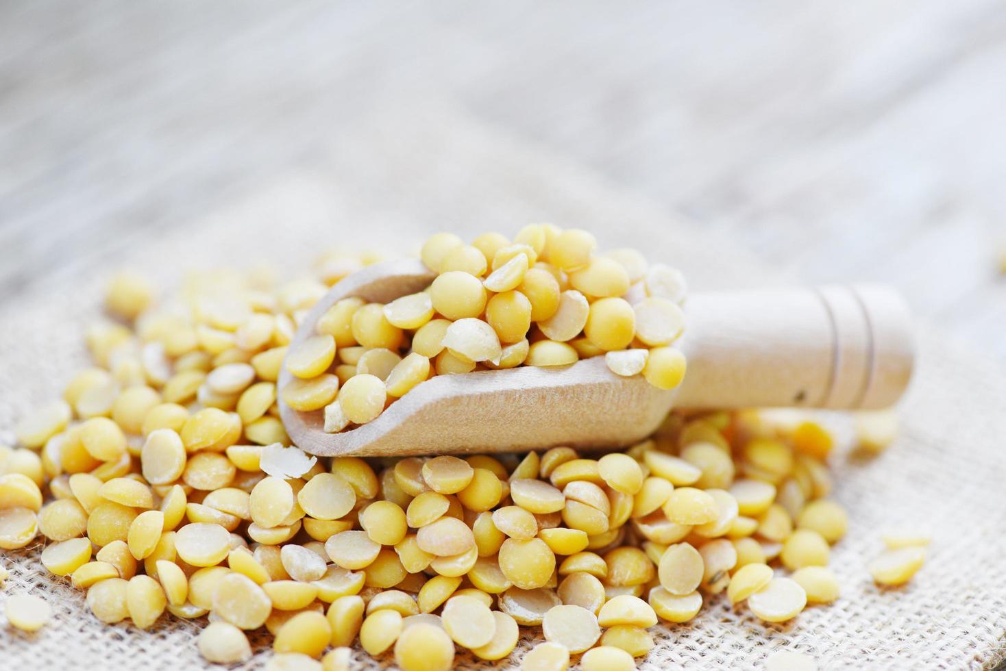 Soybean in a wooden bowl agricultural products on the sack background - Peeled Split Soybean or Soya Bean without husk photo