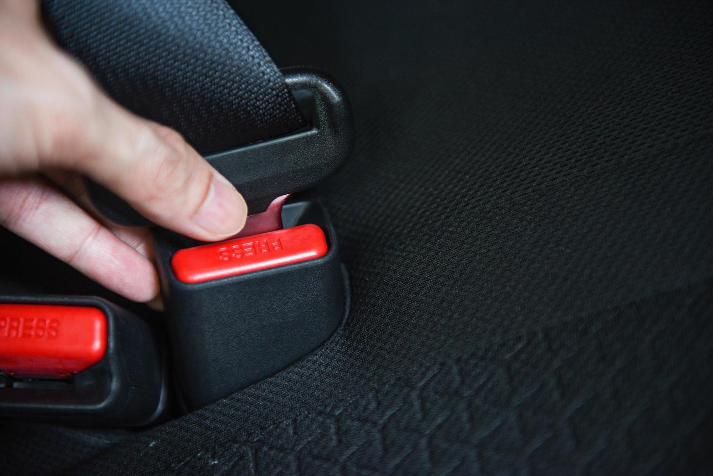 car seat belt while sitting inside the car before driving and take a safe journey - hand fastens the seat belt of the car photo