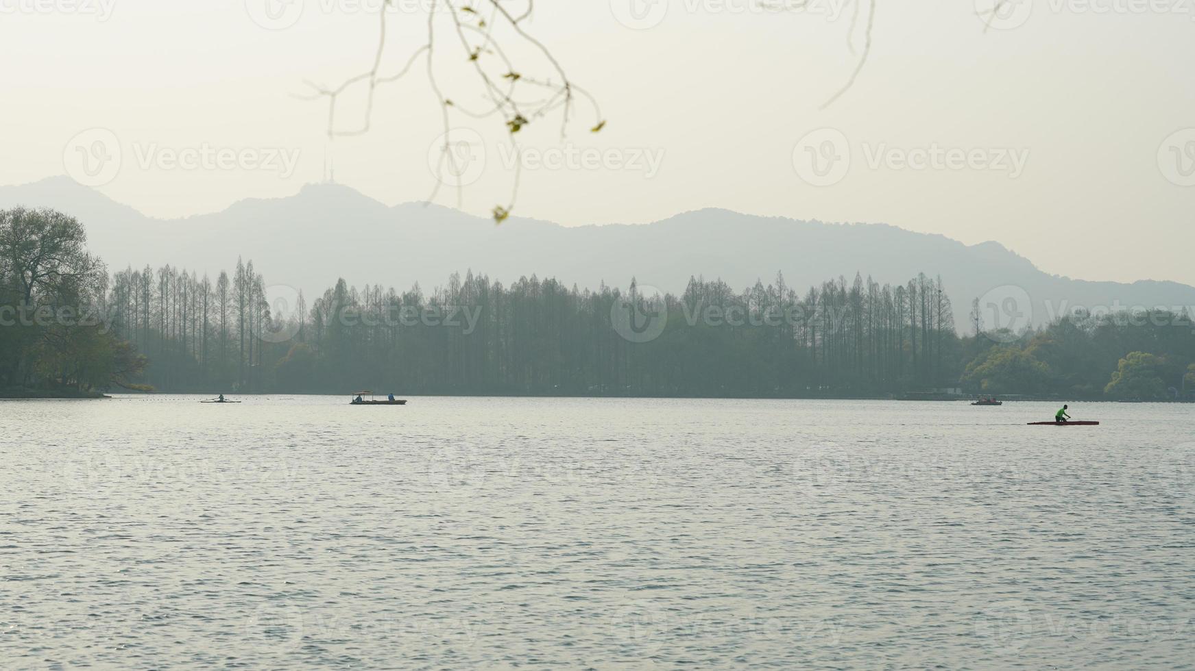 The beautiful lake landscapes in the Hangzhou city of the China in spring with the peaceful lake and fresh green mountains photo