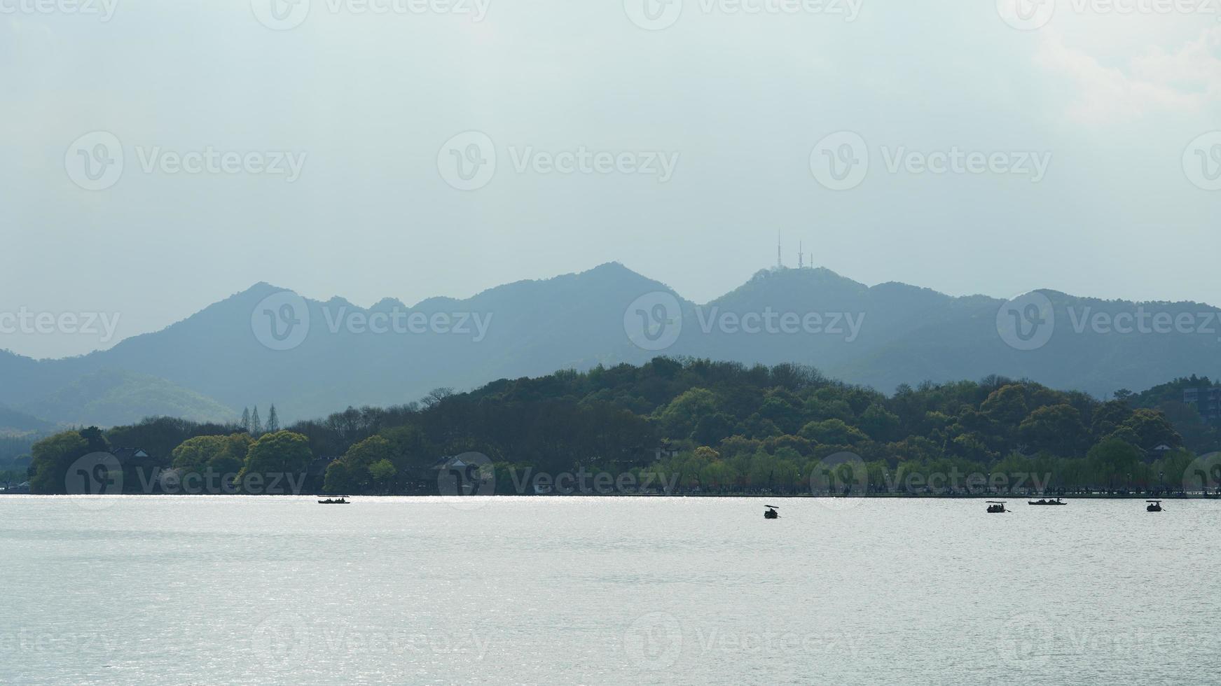 The beautiful lake landscapes in the Hangzhou city of the China in spring with the peaceful lake and fresh green mountains photo