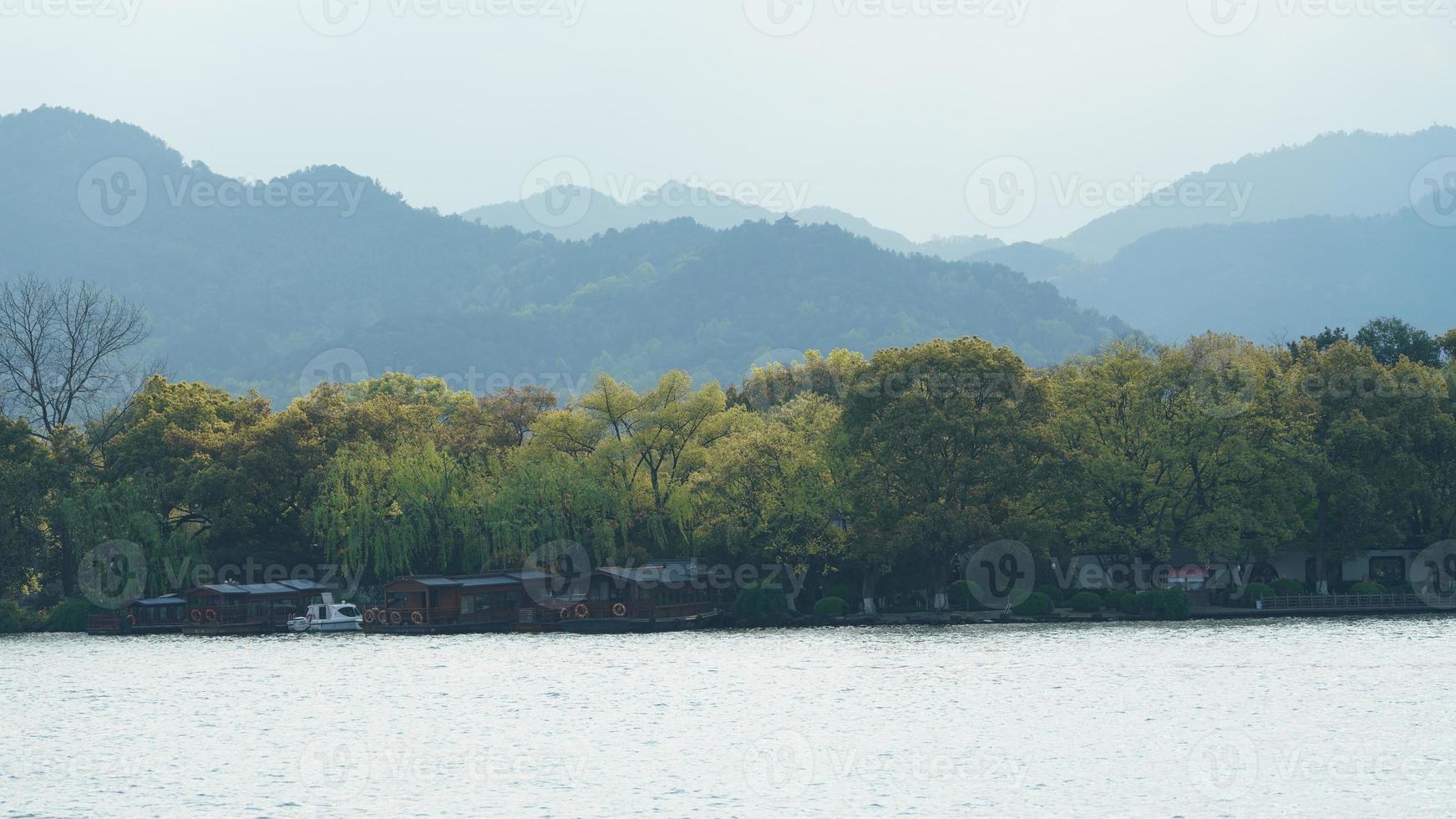 The beautiful lake landscapes in the Hangzhou city of the China in spring with the peaceful lake and fresh green mountains photo