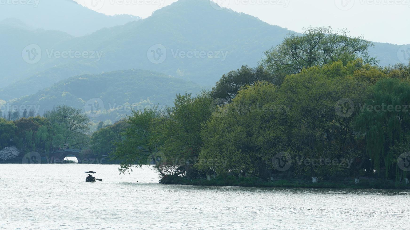 The beautiful lake landscapes in the Hangzhou city of the China in spring with the peaceful lake and fresh green mountains photo