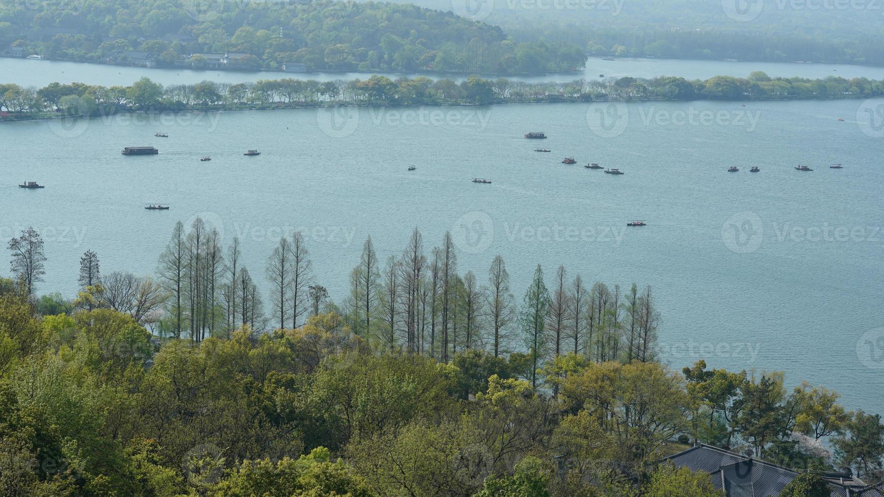 The beautiful lake landscapes in the Hangzhou city of the China in spring with the peaceful lake and fresh green mountains photo
