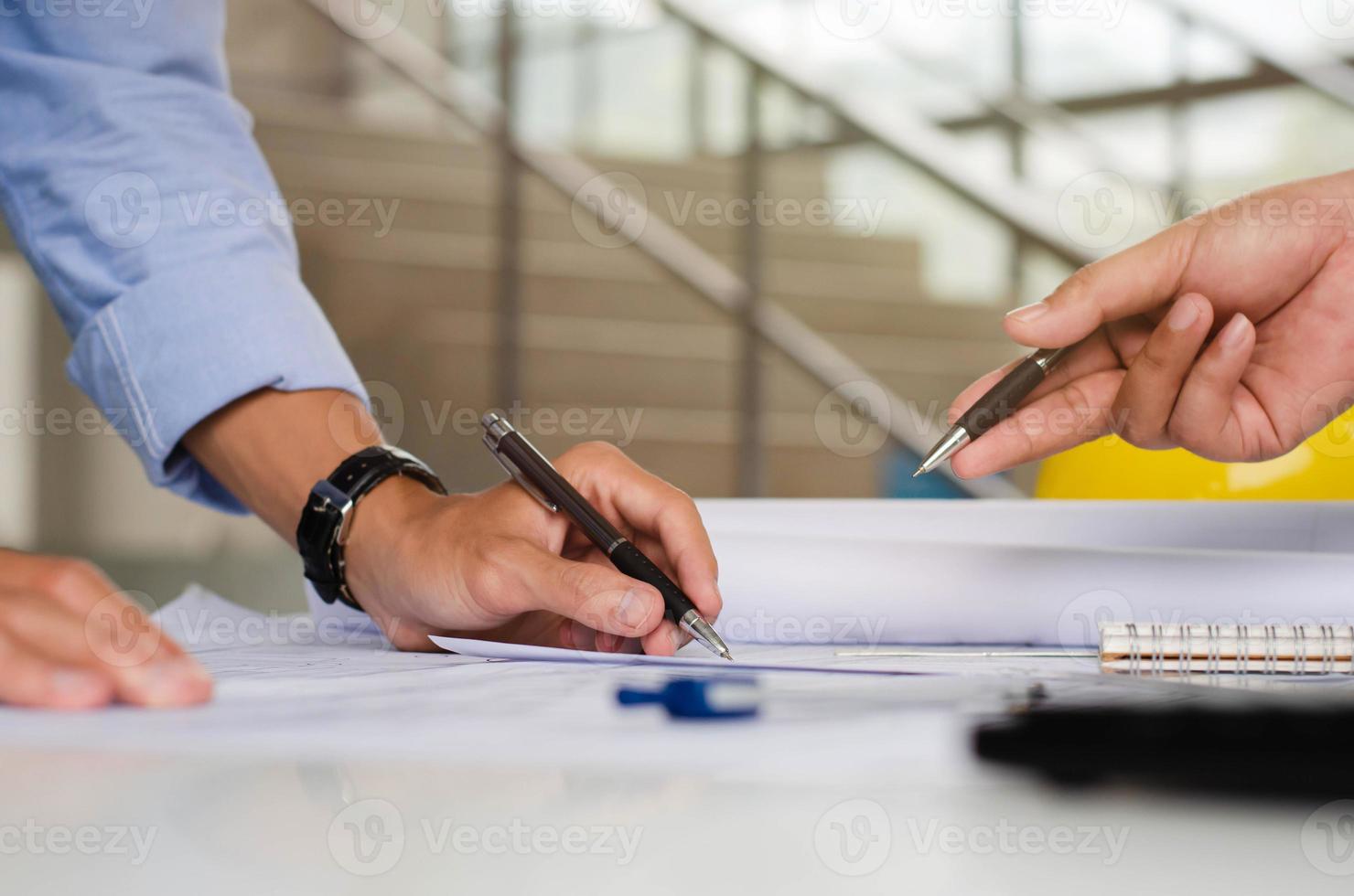 ingeniero que está planificando un borrador de la estructura. con equipos de arquitectos y discusiones en equipo sobre planos arquitectónicos en escritorios en oficinas modernas. foto