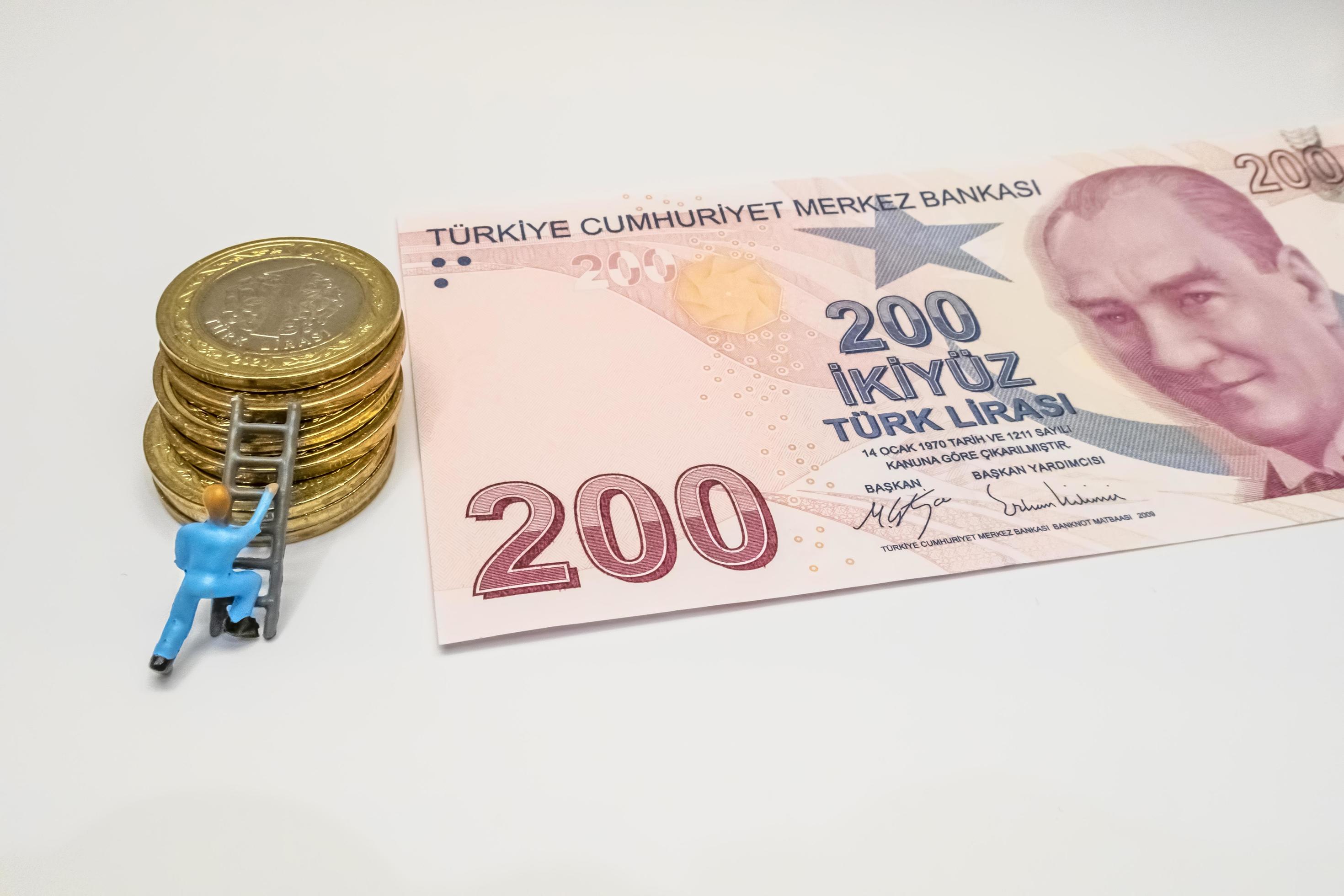 Estambul, Turquía-diciembre 24,2021.Lira turca billetes, monedas y trabajador en miniatura sobre un fondo blanco. foto