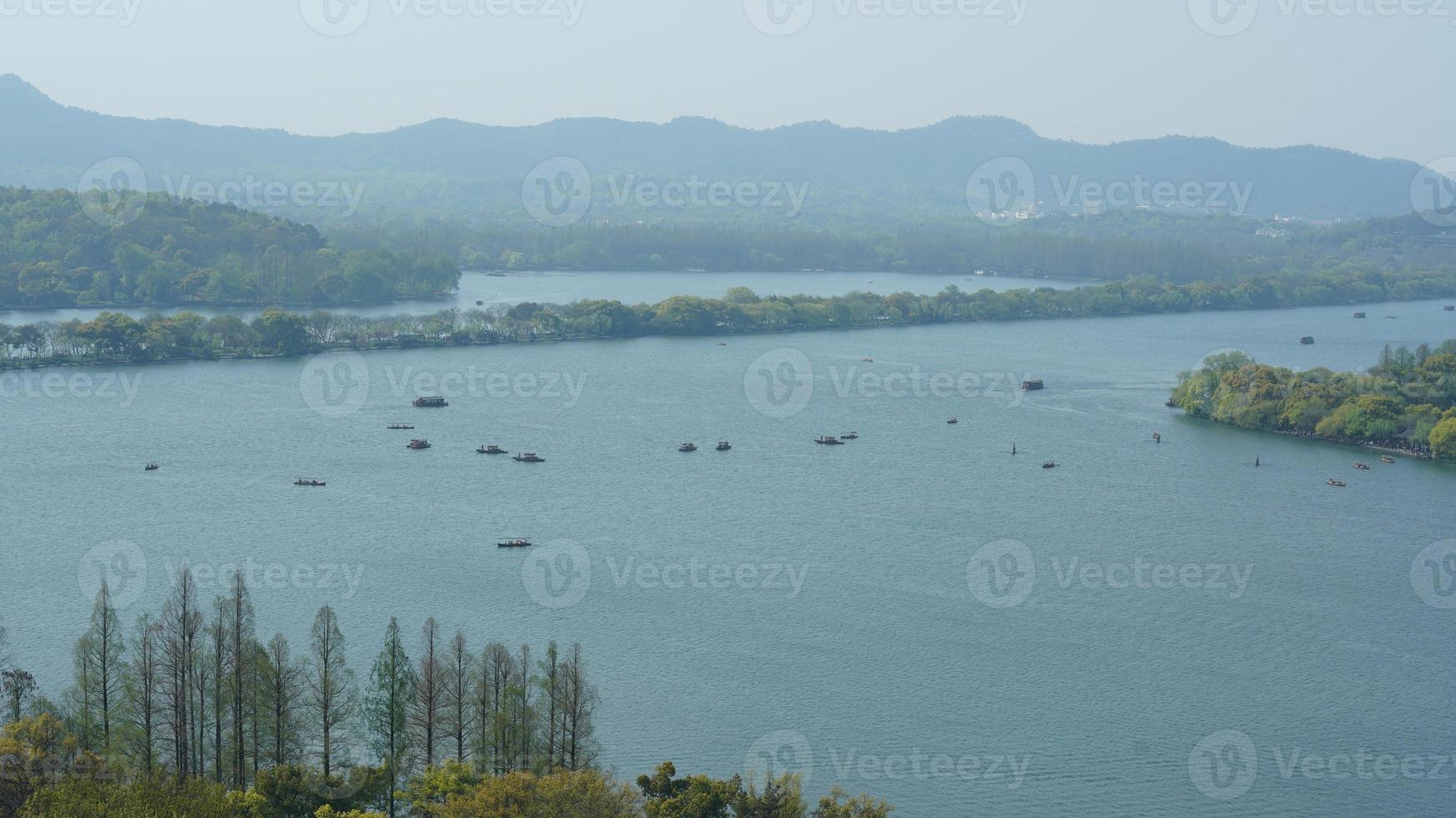 The beautiful lake landscapes in the Hangzhou city of the China in spring with the peaceful lake and fresh green mountains photo