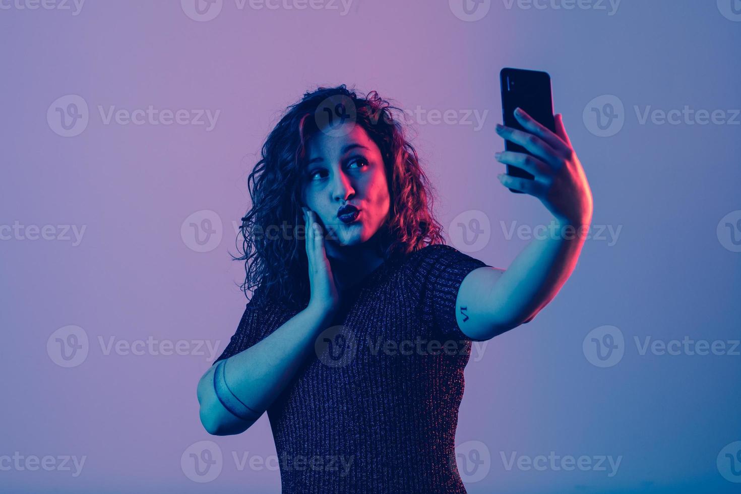 young girl making selfie and sending kiss photo