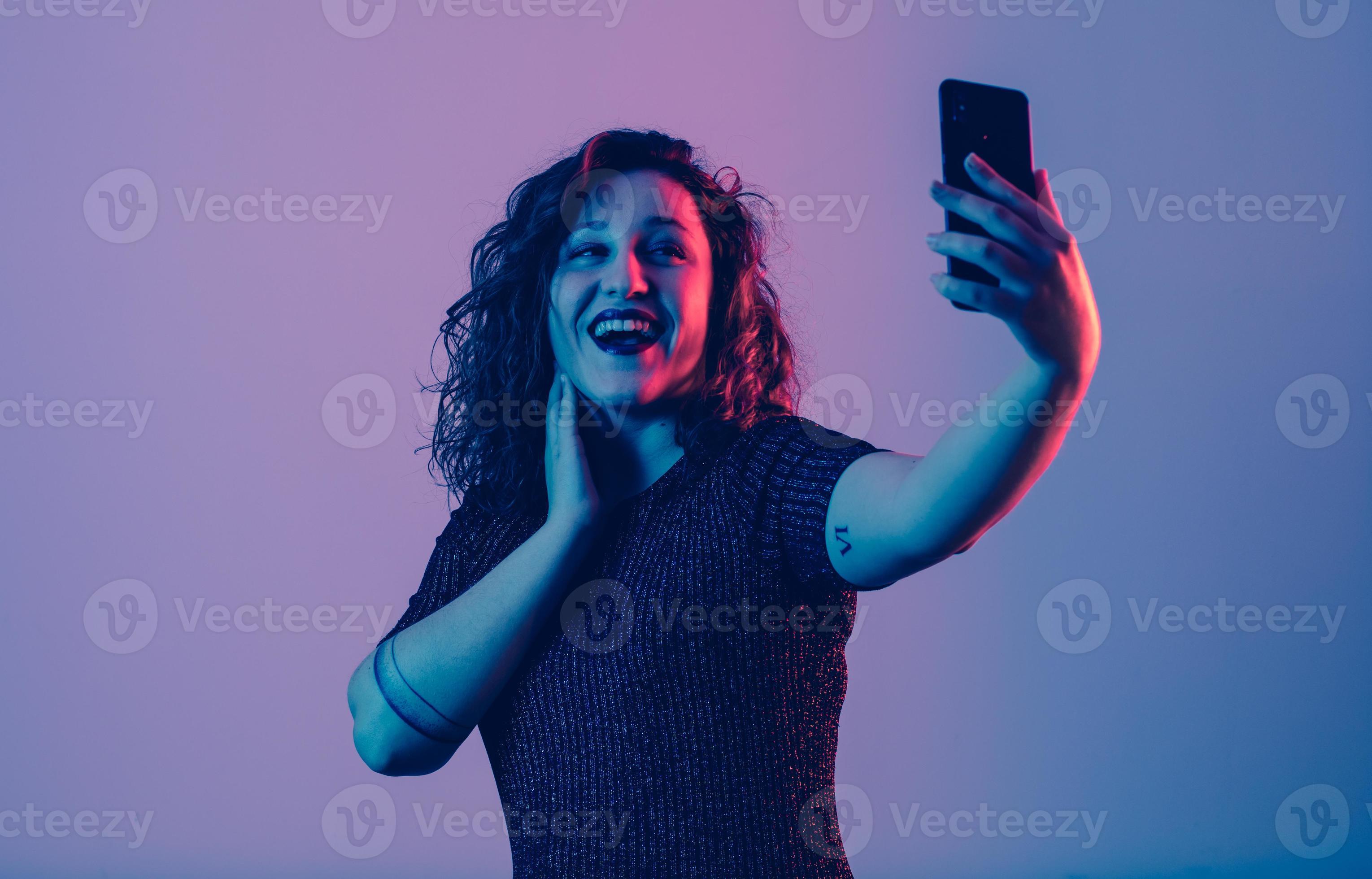 Chica joven haciendo selfie y divirtiéndose en una fiesta foto