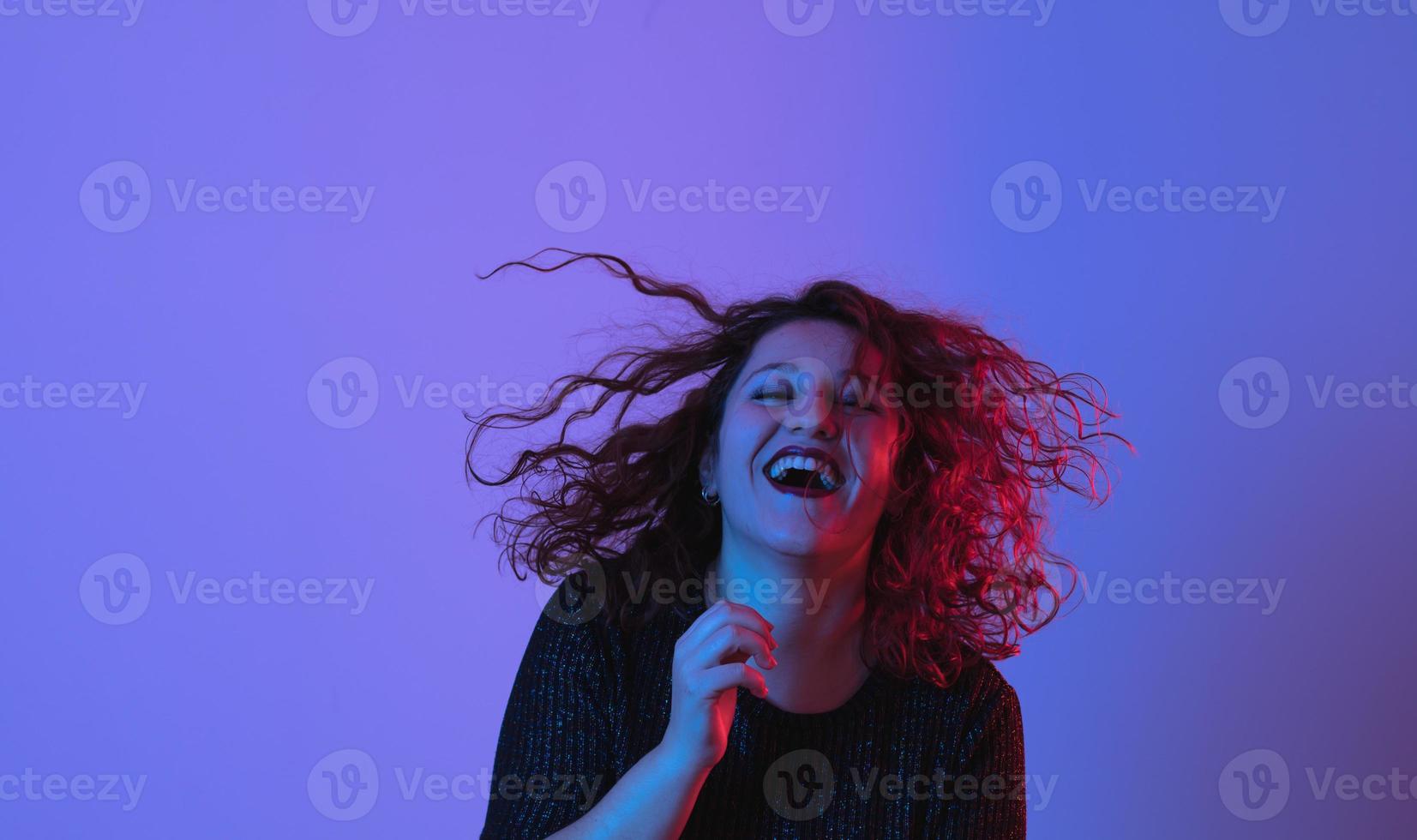 Girl dancing and having fun at party. Colorful light, Studio shot, copyspace photo