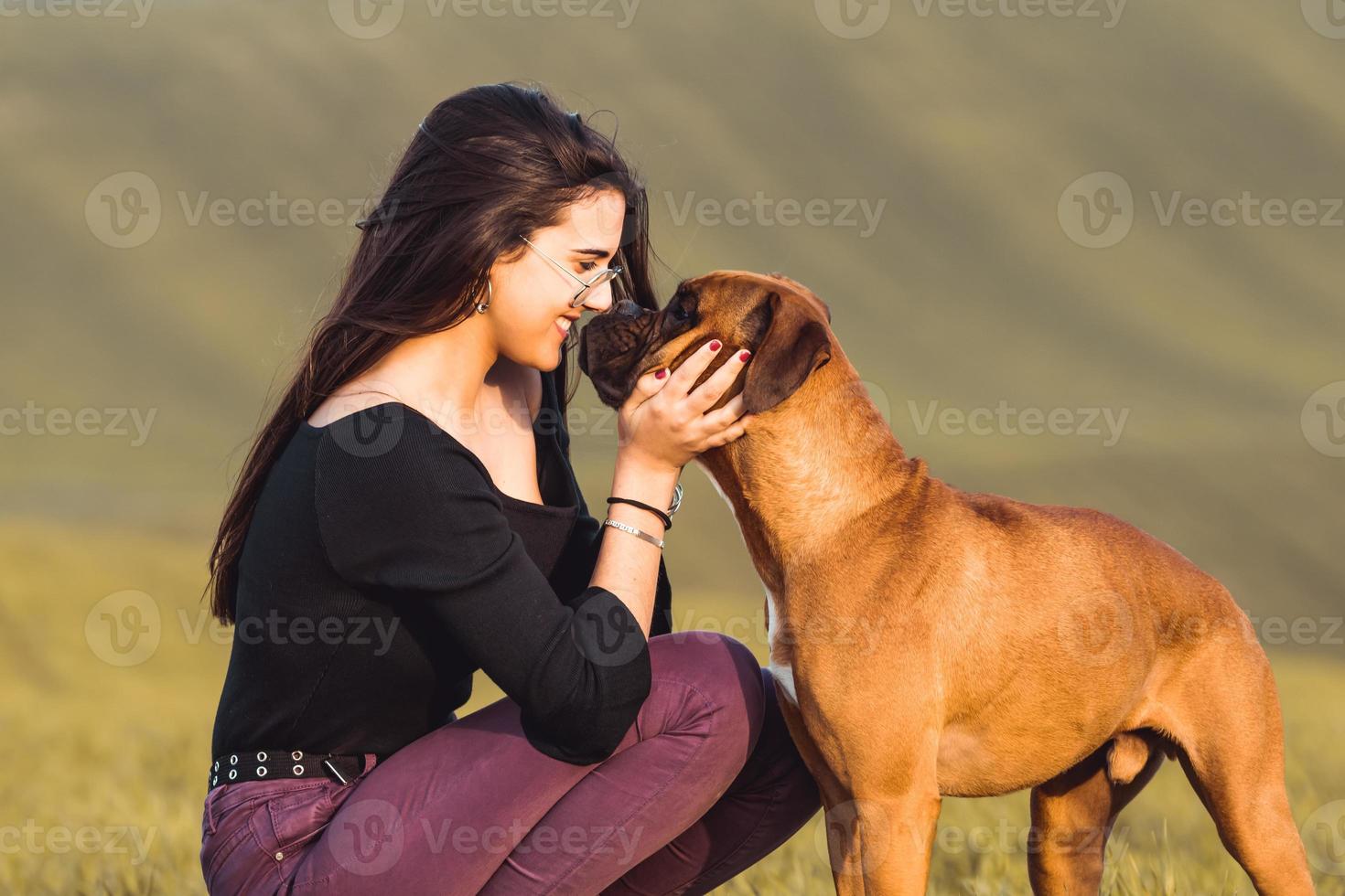 chica de moda con su perro boxer en la pradera en otoño foto