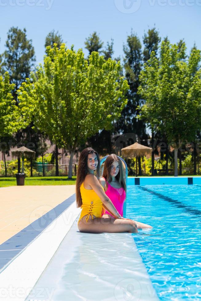 Two teenagers girls at swimming pool photo