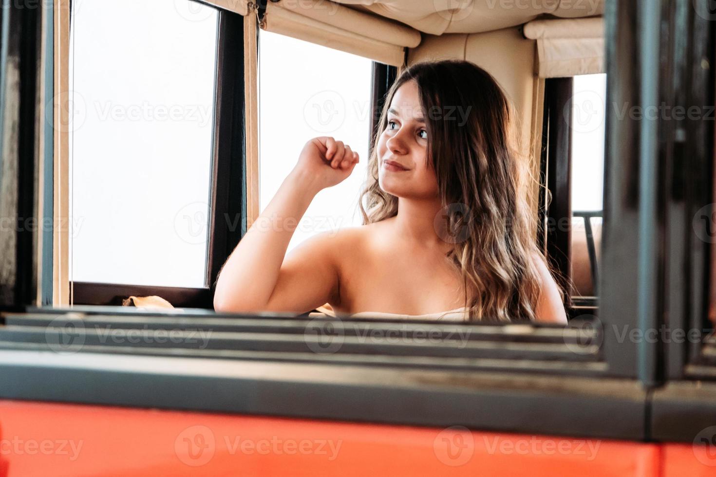 Un primer plano de una mujer caucásica sentada en el autobús y mirando por la ventana foto