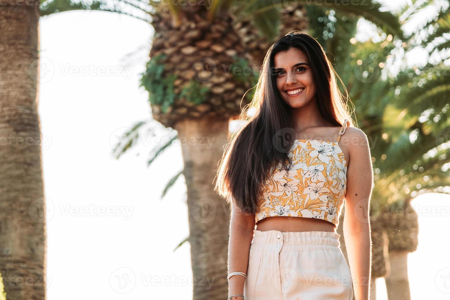 A young caucasian female in front of the trees during daytime photo